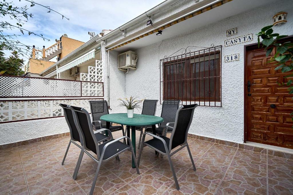 ラ・マタにあるEspanhouse Diana bungalowの緑のテーブルと椅子が備わるパティオ