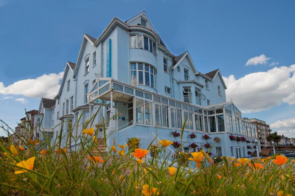 a large white building with flowers in front of it at Marine Hotel in Paignton
