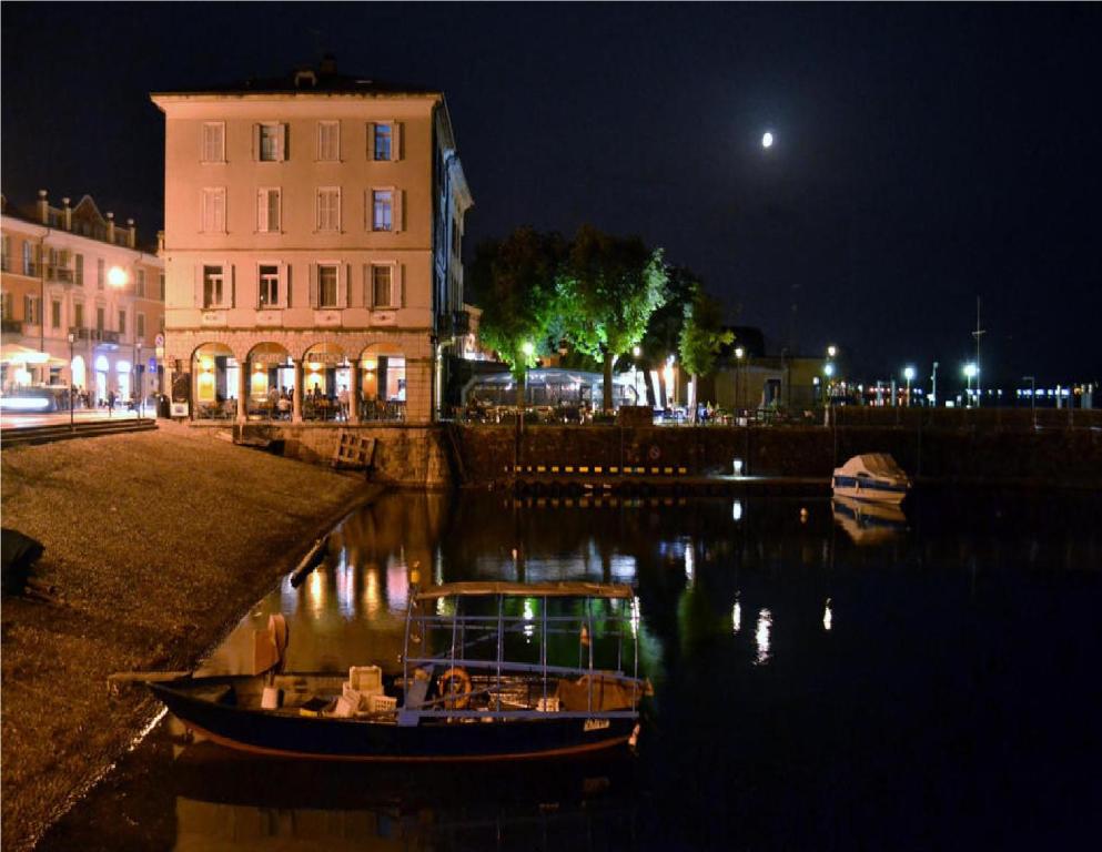 un barco en el agua cerca de un edificio por la noche en Il Soppalco, en Luino