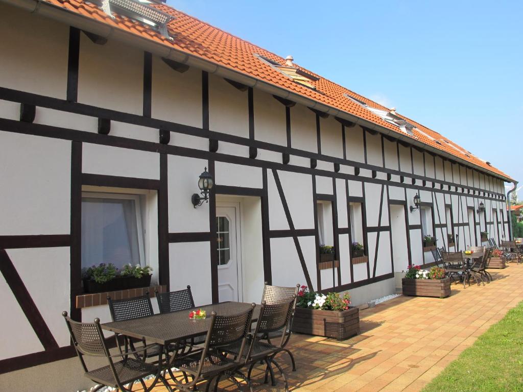 a black and white building with a table and chairs at Ferienwohnungen Pustane in Neu Zauche