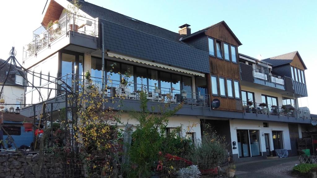 ein großes Haus mit Balkon auf einer Straße in der Unterkunft Gästehaus Moselblick in Trittenheim