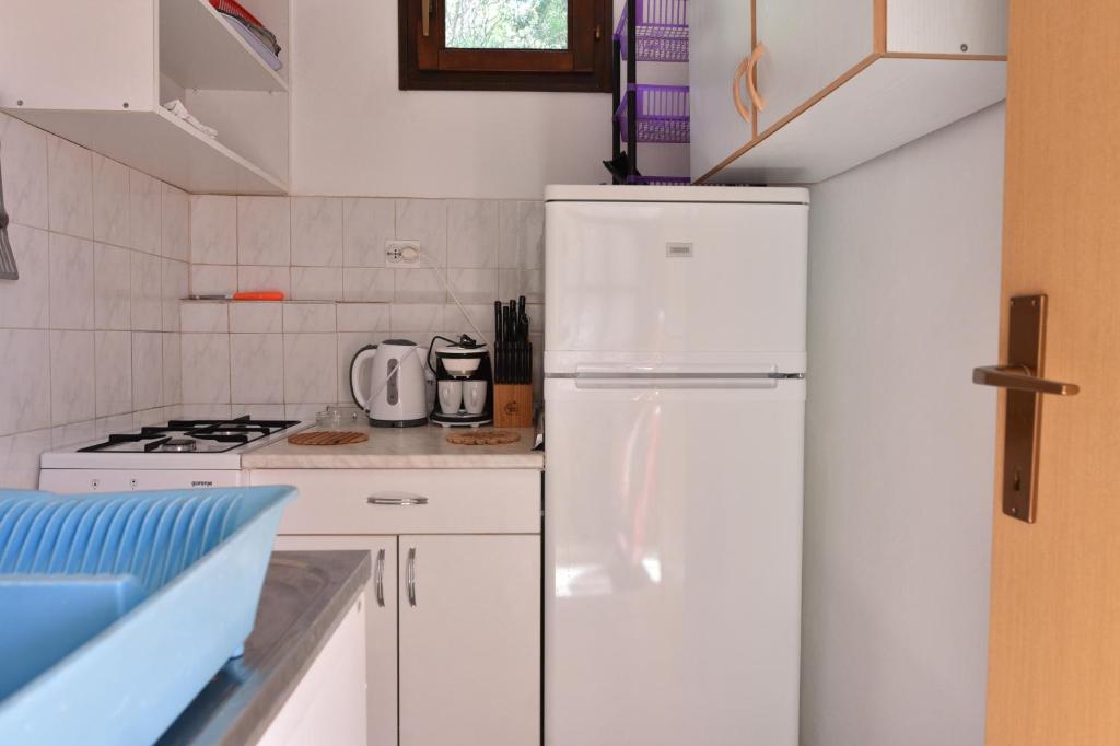 a white kitchen with a refrigerator and a stove at Apartmani Marko in Gdinj