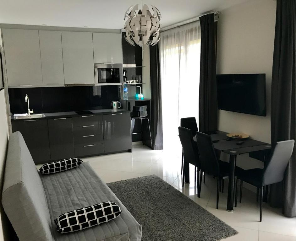 eine Küche und ein Wohnzimmer mit einem Sofa und einem Tisch in der Unterkunft MOKO Apartment in Warschau