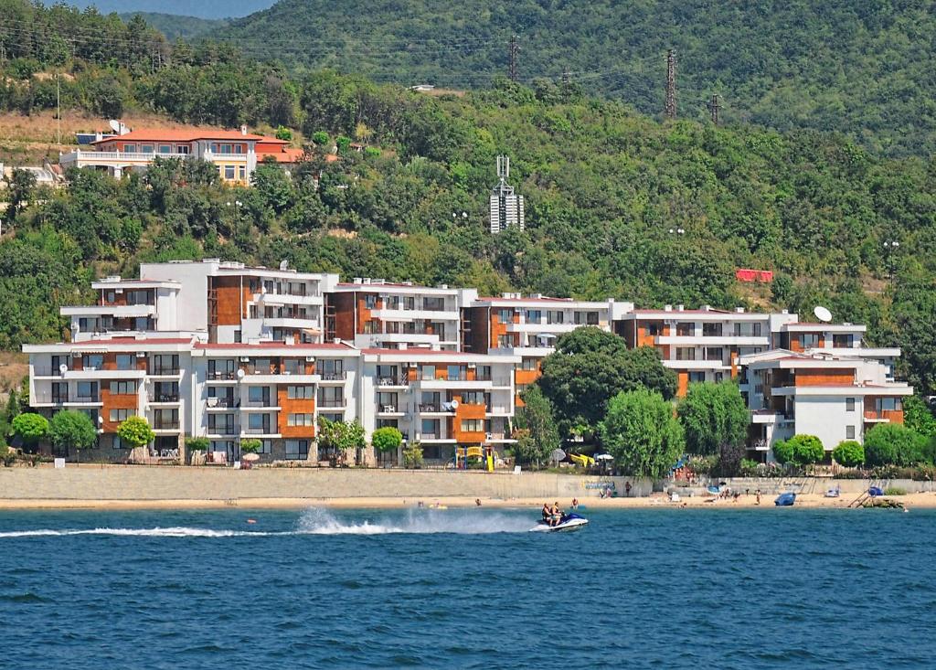 een boot in het water voor een strand bij Messambria Beach Apartments in Sveti Vlas