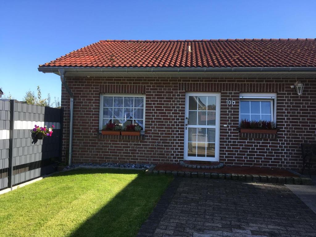 a brick house with two windows and a yard at Ferienwohnung "Am Radweg" in Telgte