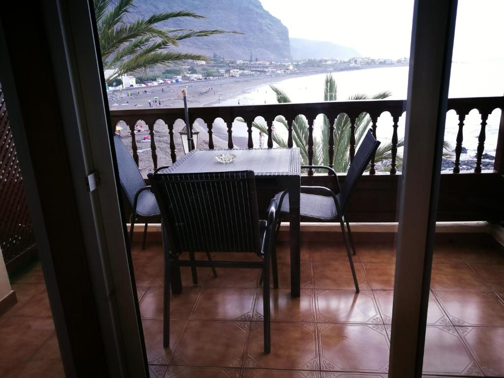 a table and chairs on a balcony with a view of a beach at Apartamentos Playamar in La Playa Calera