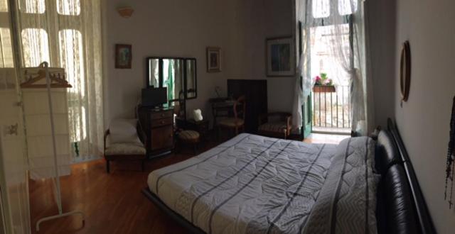 ein Schlafzimmer mit einem Bett und ein Wohnzimmer in der Unterkunft In Via Roma in Salerno