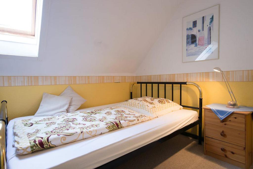 a bedroom with a bed and a lamp on a dresser at Kleines Hotel Wemhoff in Winterberg