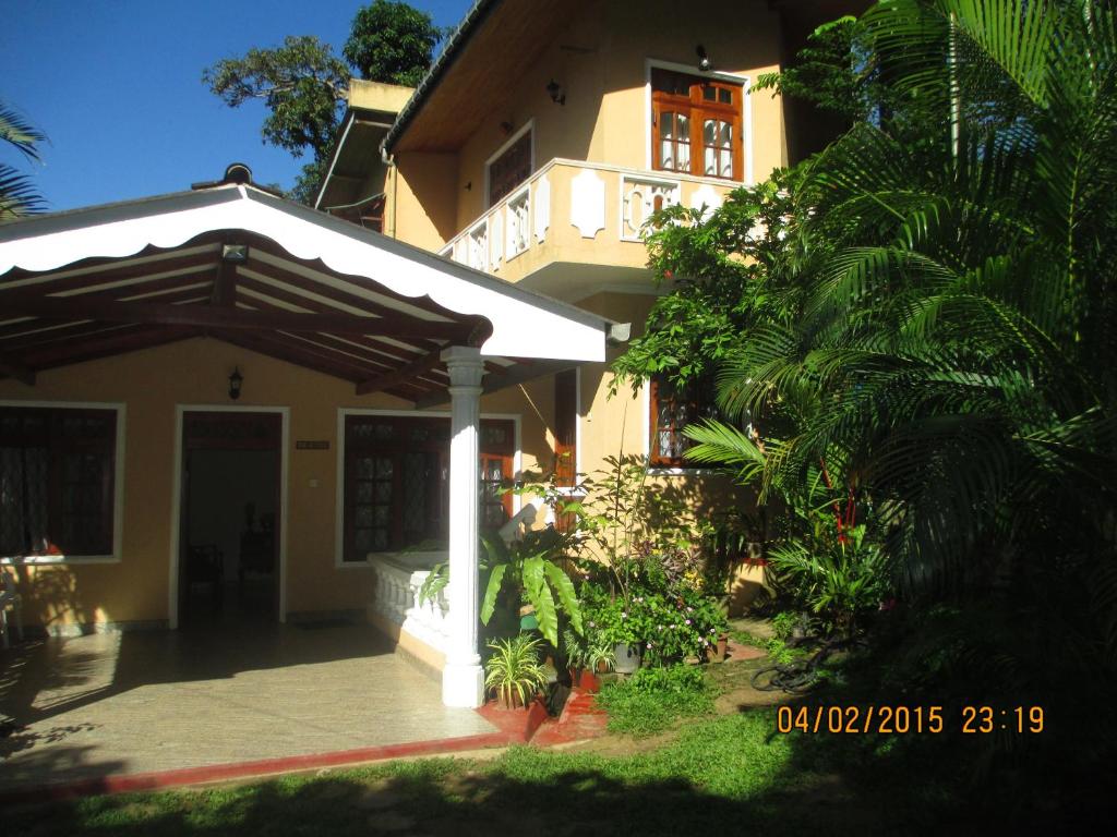 una casa con porche y un edificio en Staykandy, en Kandy