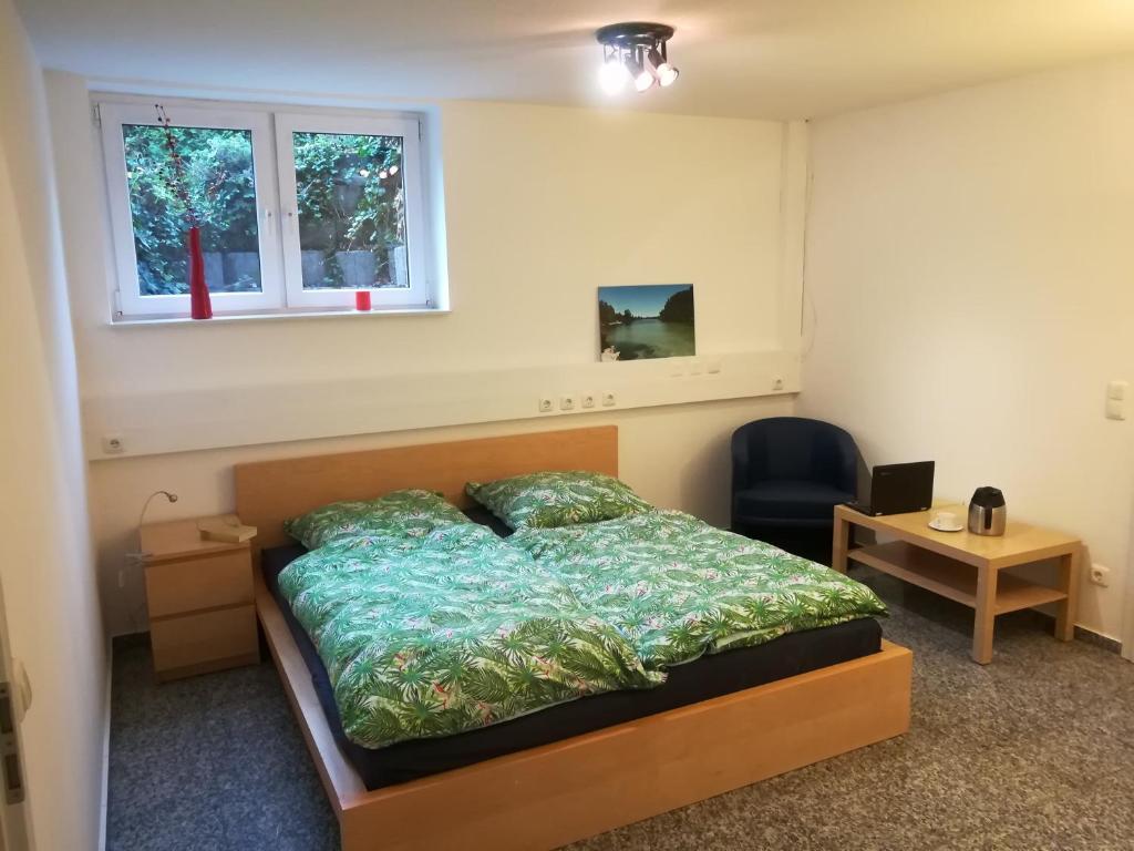 Schlafzimmer mit einem Bett, einem Schreibtisch und einem Fenster in der Unterkunft Private Apartment Ahlten in Lehrte