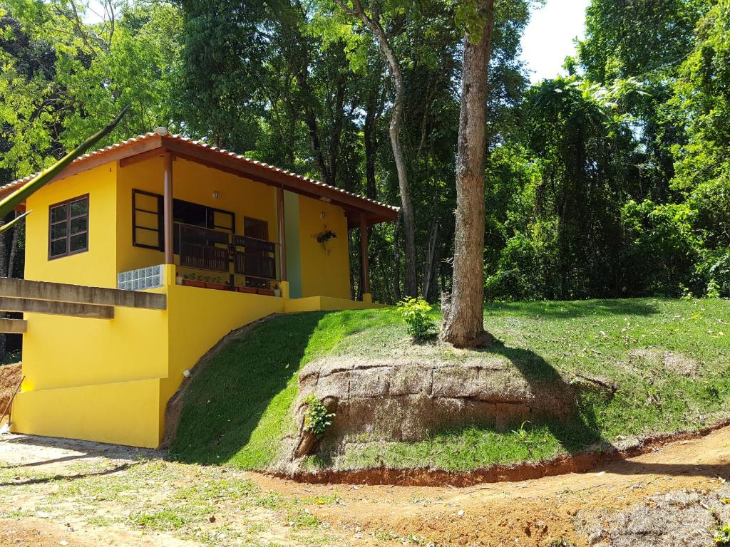 a yellow house sitting on top of a tree stump at Pousada Do Moinho in Nazaré Paulista