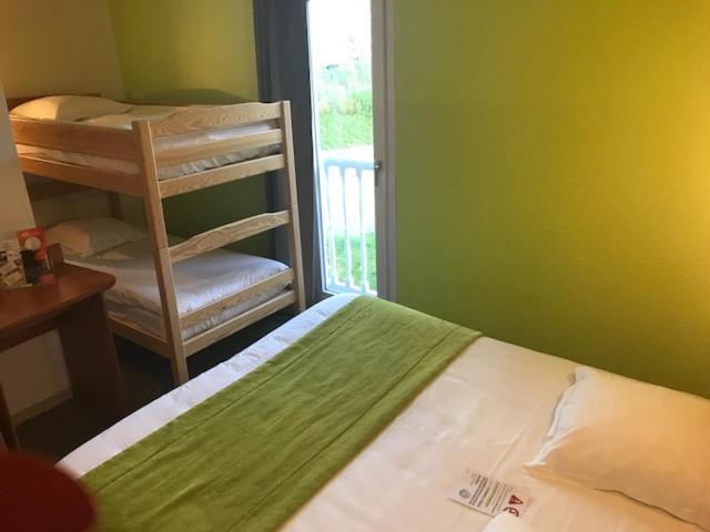 La Chapelle-Saint-LucにあるBrit Hotel Essentiel Troyes Aéroportのベッドルーム1室(ベッド1台、二段ベッド1組、椅子付)