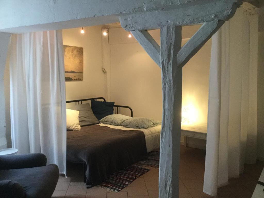 サン・テニャンにあるLa petite maison d’à côté, au n°11のベッドルーム1室(木製の天蓋付きベッド1台付)