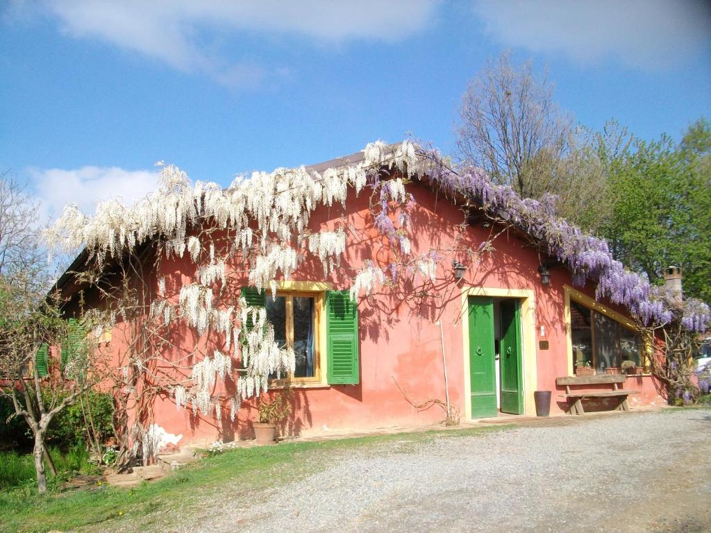 ノーヴィ・リーグレにあるAgriturismo Cascina degli Uliviの白い植物が並ぶピンクの家