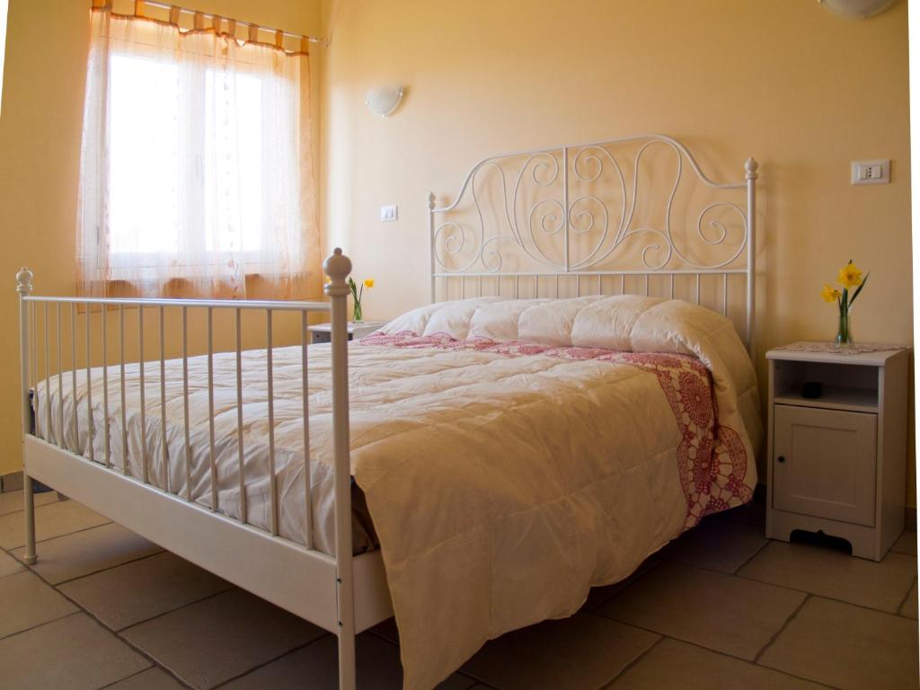 ein Schlafzimmer mit einem Bett mit einem weißen Bettrahmen in der Unterkunft B&B La Rosa dei Venti in Montesilvano