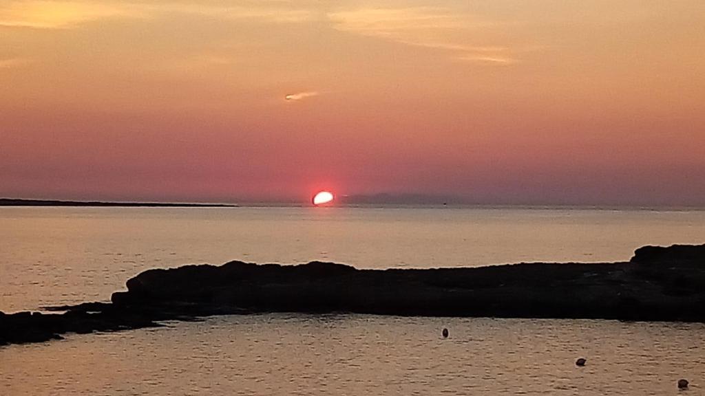 un coucher de soleil sur l'océan et le soleil à l'horizon dans l'établissement Deliziosa Villetta Mancaversa, à Marina di Mancaversa