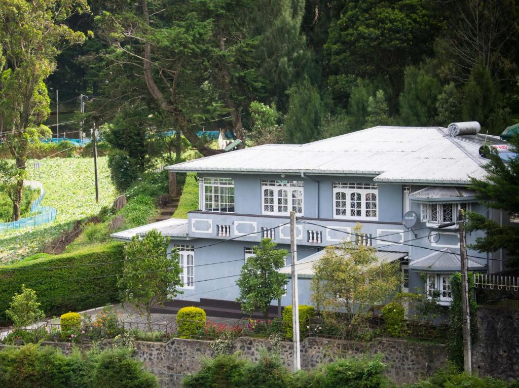una casa blanca con techo gris en Mount Mary Inn, en Nuwara Eliya