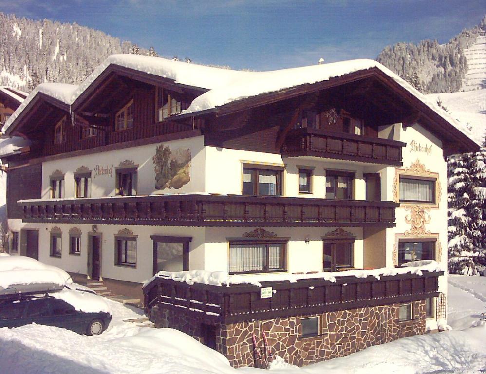 une grande maison recouverte de neige dans l'établissement Appartements Birkenhof, à Berwang