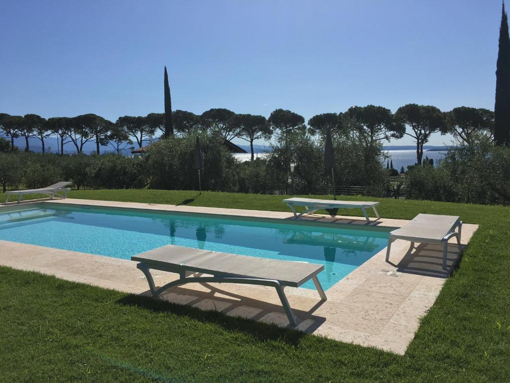 a swimming pool with two benches and a picnic table at Agriturismo Nonna Bettina in Moniga