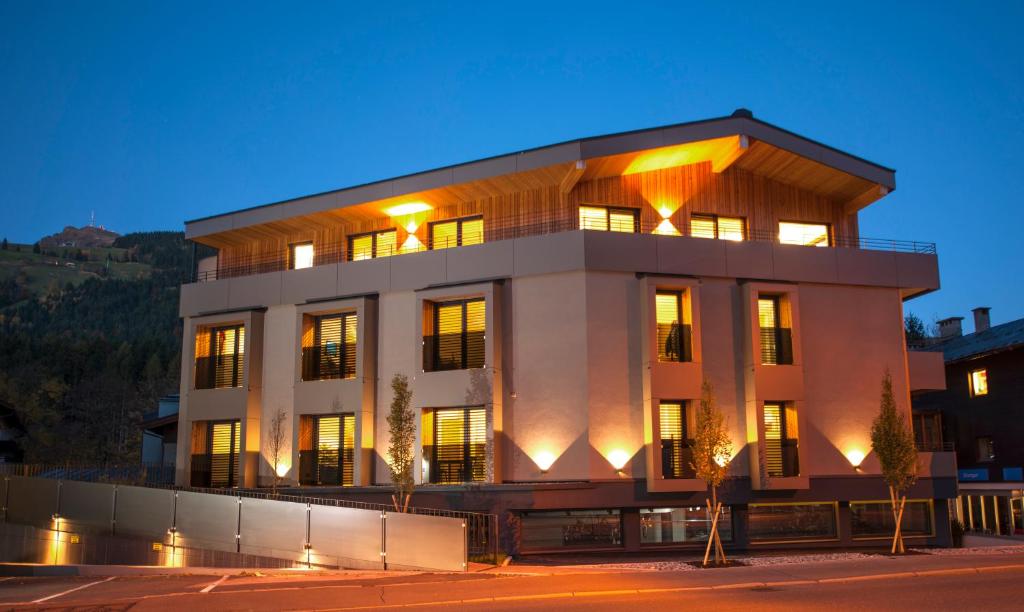 a large white building with lights on at Kitzlife Apartements in Kitzbühel