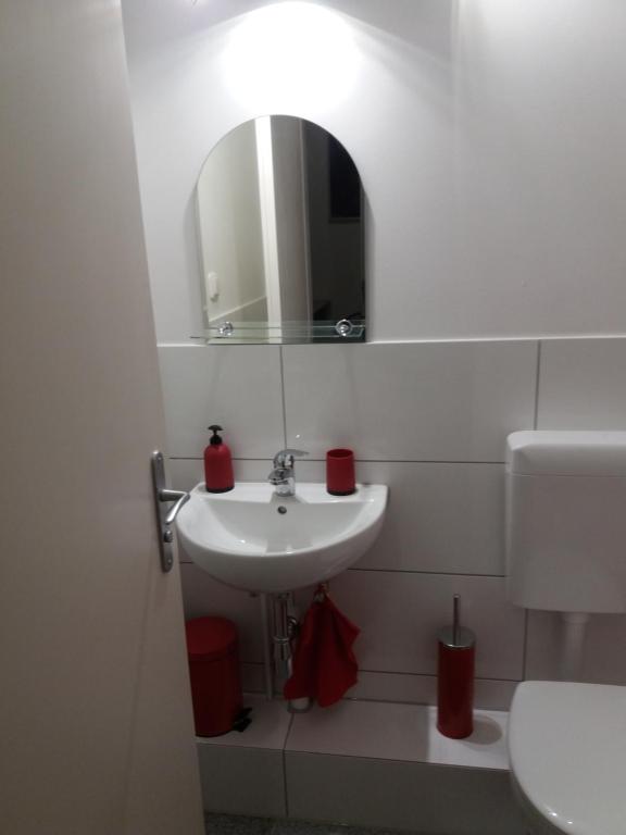a white bathroom with a sink and a mirror at Ferienwohnung in Berlin