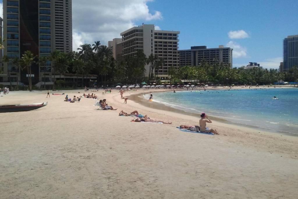 a group of people sitting on a beach at Palms Waikiki #412 in Honolulu