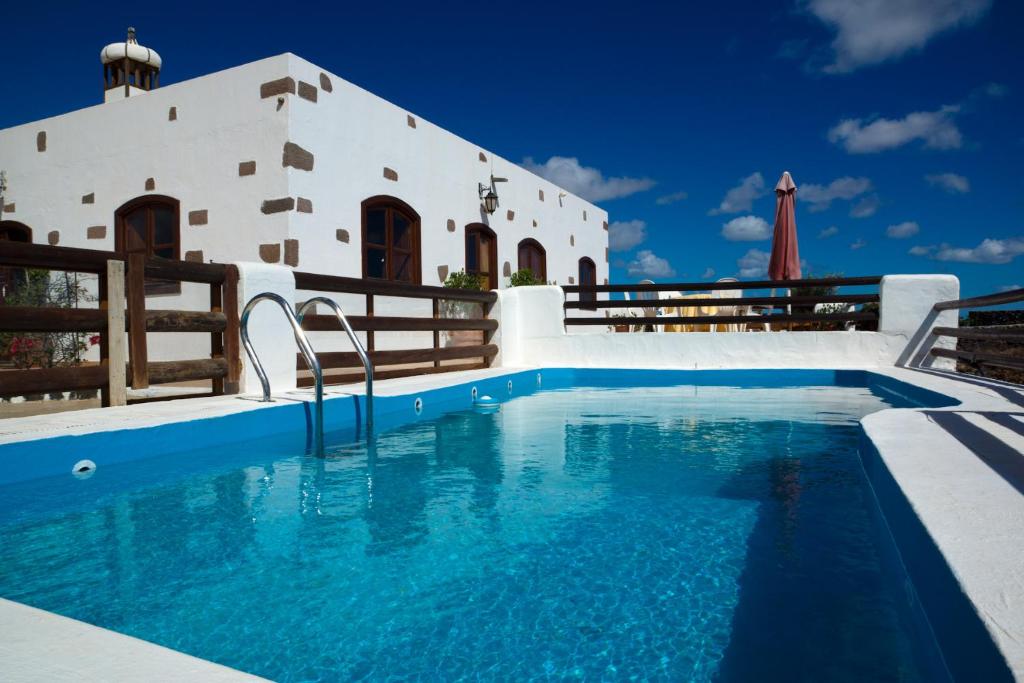 a villa with a swimming pool in front of a building at Villas Macher in Tías