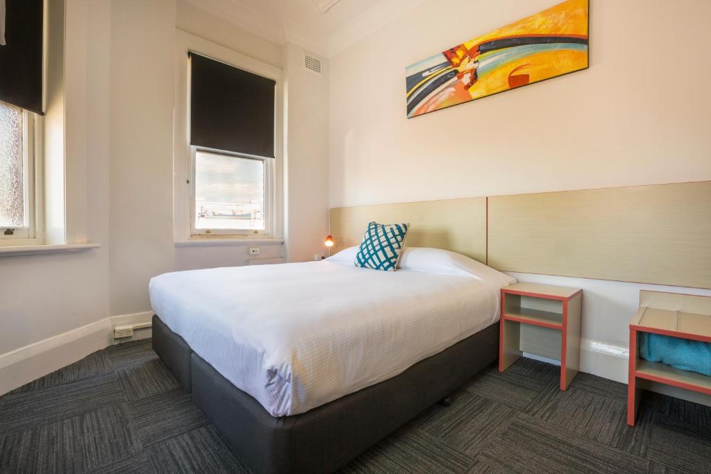 1 dormitorio con 1 cama y una pintura en la pared en Melton Hotel Auburn en Sídney