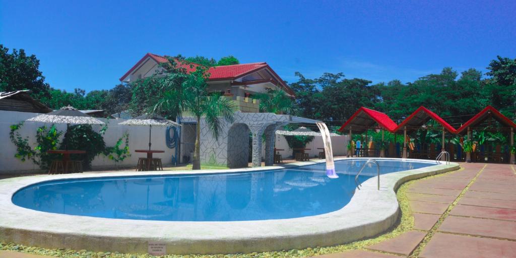 a swimming pool in a yard with a house at Michelle Pension in Puerto Princesa City