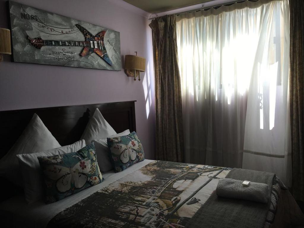 a bedroom with a large bed with a window at Tassili Lodge in Kempton Park