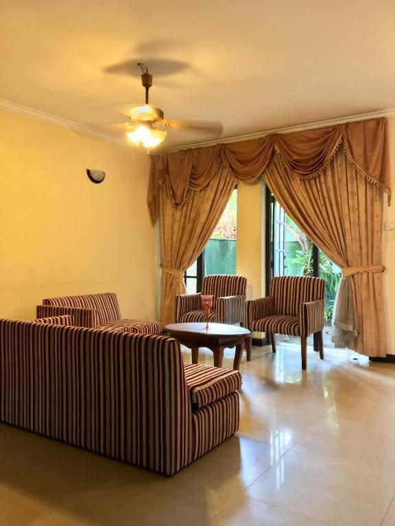 a living room with couches and a table and windows at Noahs Ark Transit Stay in Moratuwa