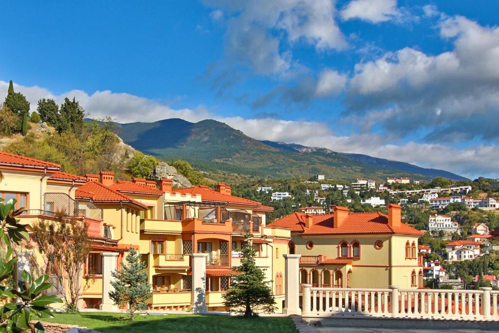 un grupo de casas con una montaña en el fondo en Villa Balgatura Concept Hotel & Apartaments, en Hurzuf