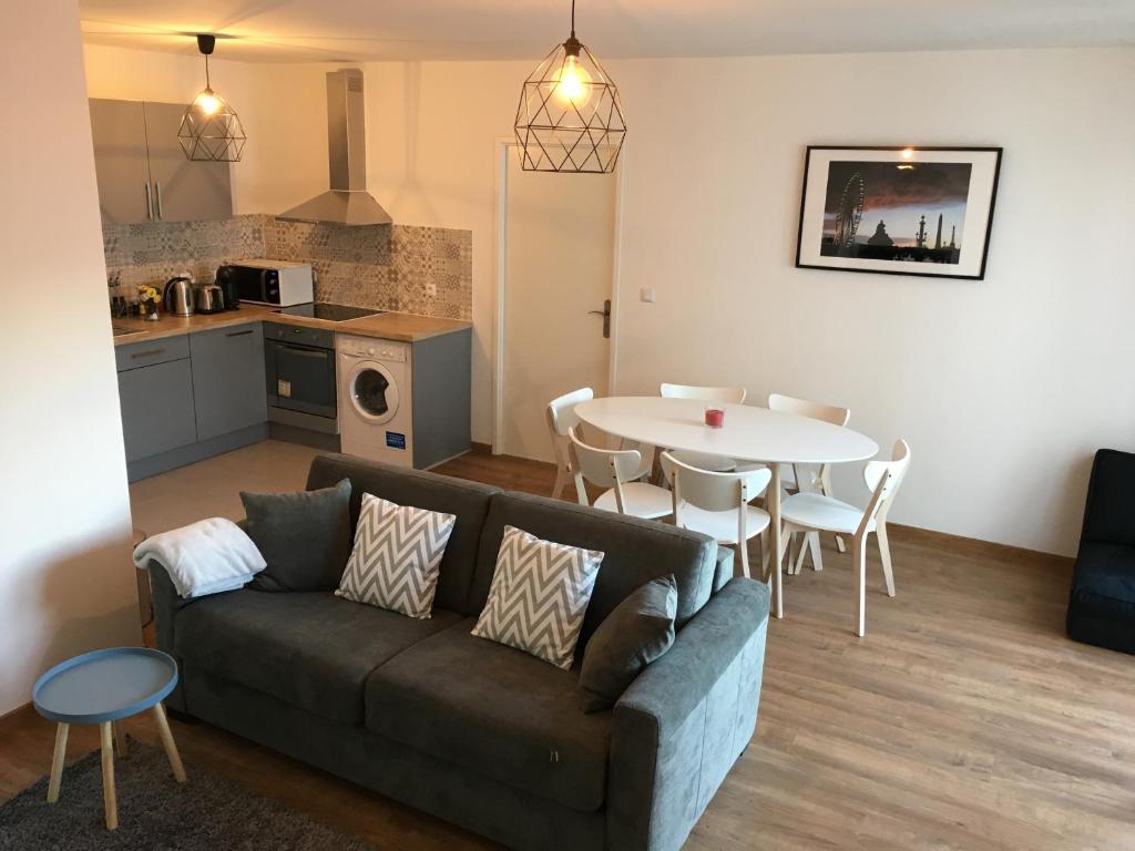 a living room with a couch and a table at Sleep in Paris Val d'Europe in Chessy
