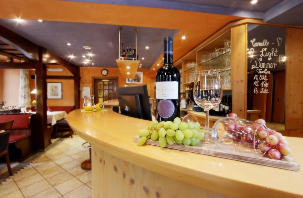 eine Theke mit einer Flasche Wein und Trauben darauf in der Unterkunft Hotel Restaurant Reichsadler in Buchen