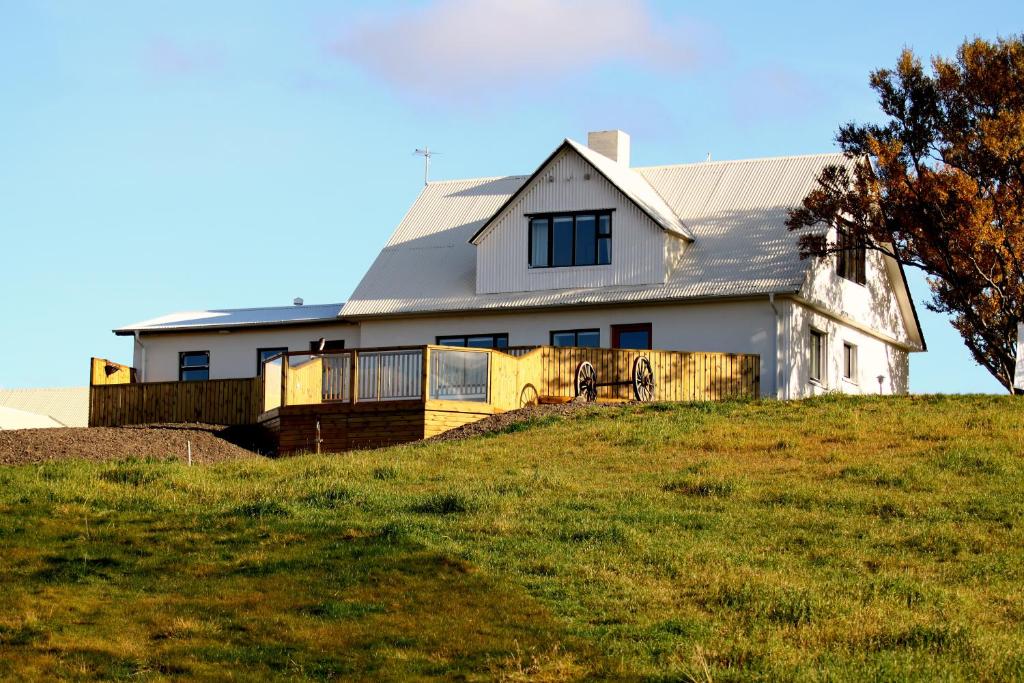 a white house on top of a hill at Guesthouse Steindórsstadir, West Iceland in Reykholt