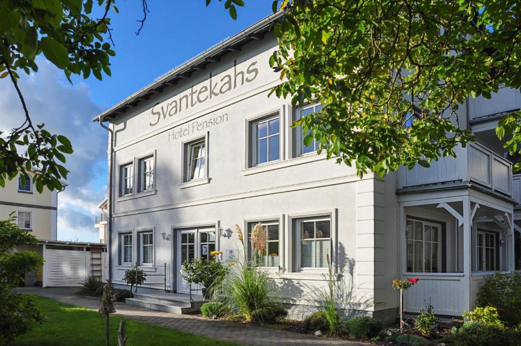 un edificio blanco con un cartel. en Haus Svantekahs, en Glowe