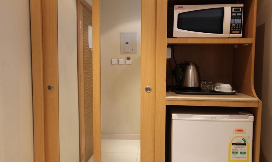 una pequeña cocina con microondas y nevera. en Meera Suites, en Riad