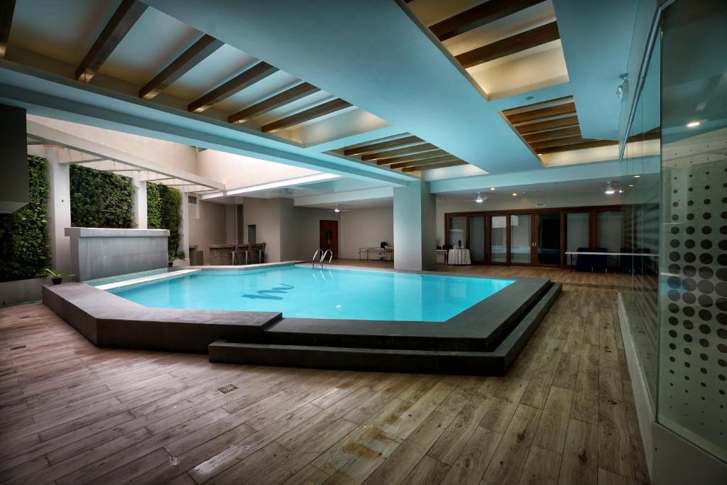 a large pool in a room with a wooden floor at Mezzo Hotel in Cebu City