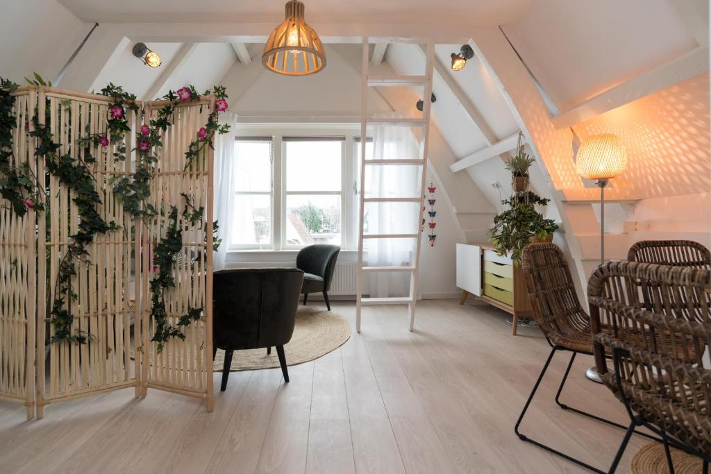 sala de estar con mesa y flores en la pared en Way Up Studio en Ámsterdam