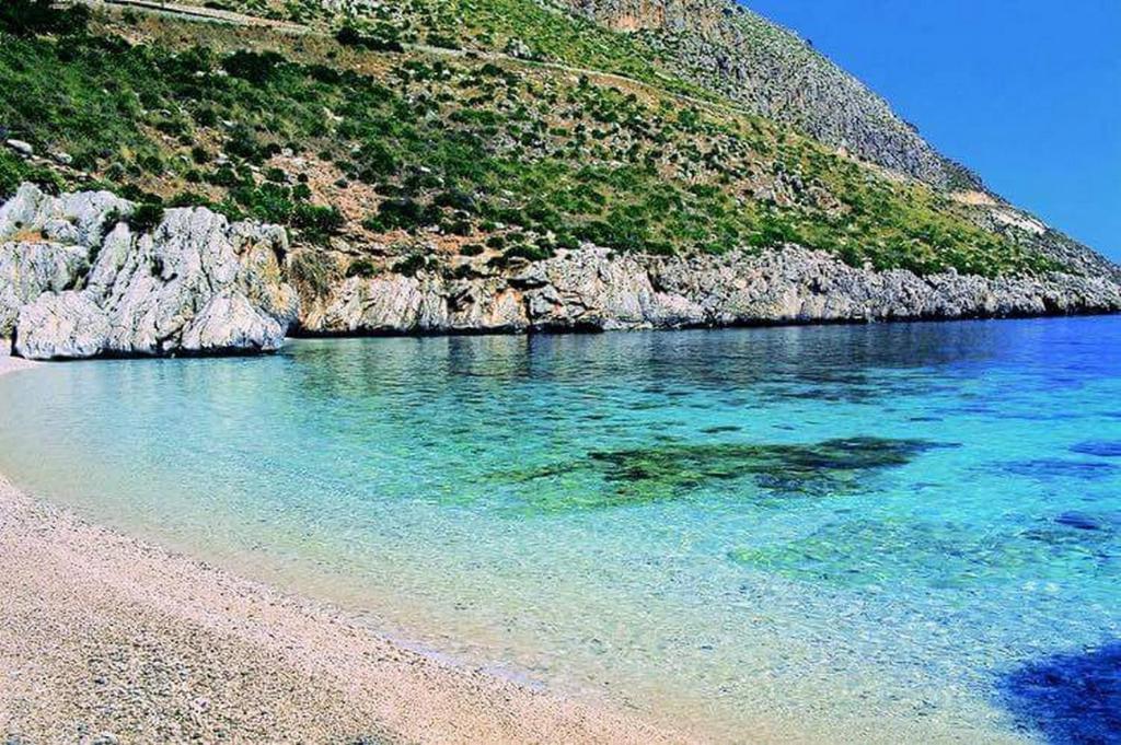 a beach with clear blue water next to a mountain w obiekcie Casa Rachele ad Alcamo Marina w mieście Alcamo Marina