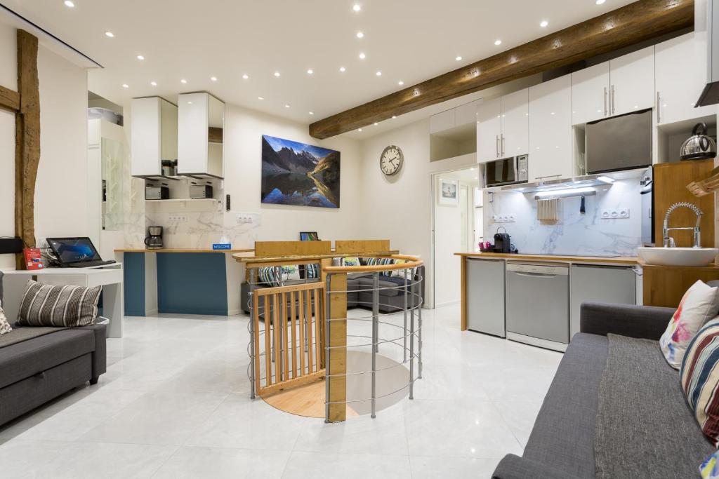 an open kitchen and living room with a couch at Louvre Luxury Apartment & SPA in Paris