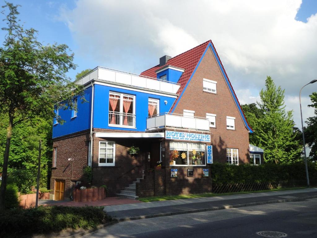 un edificio azul al lado de una calle en Hotel Garni Nolting, en Esens