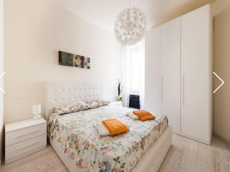 フィレンツェにあるModern Apartment Sant'Antoninoの白いベッドルーム(ベッド1台、シャンデリア付)