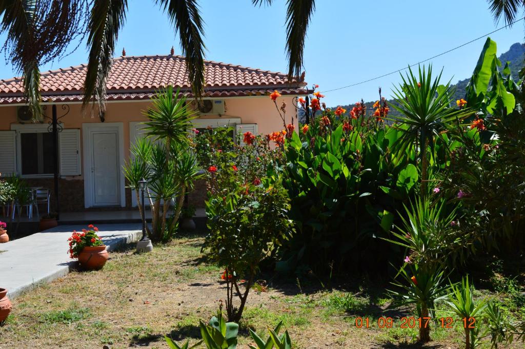 a house with flowers and plants in front of it at Garden View Apartments in Anaxos