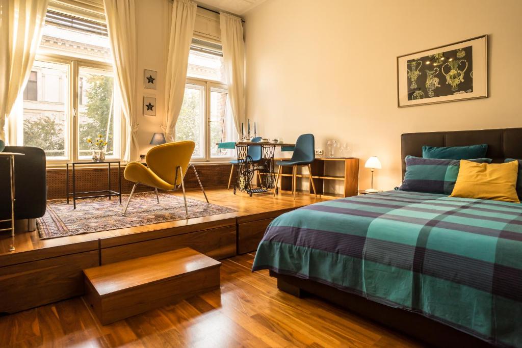 a bedroom with a bed and a table and chairs at Parliament Suite with a view in Budapest