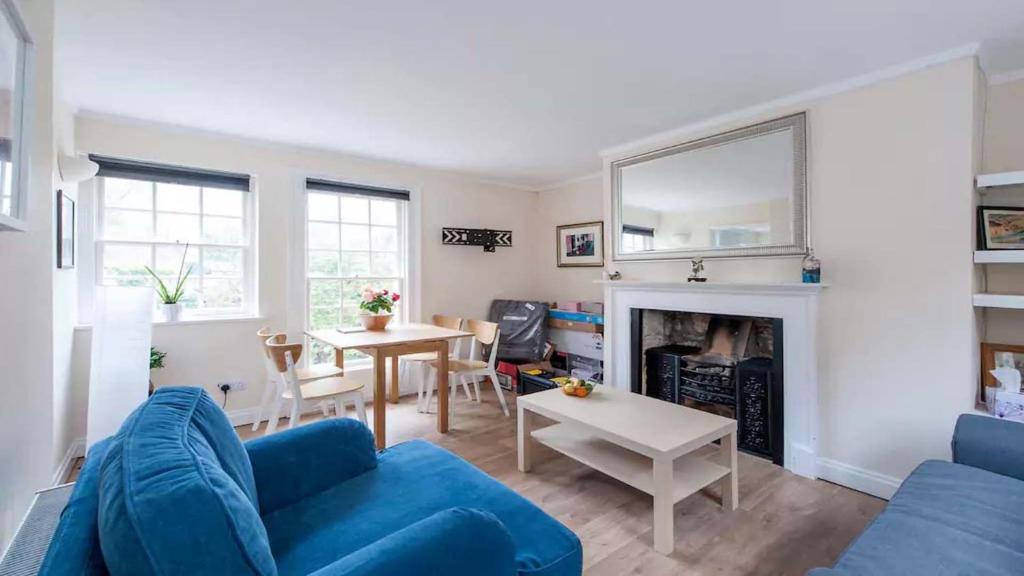 a living room with a blue couch and a table at New King Street Apartment in Bath