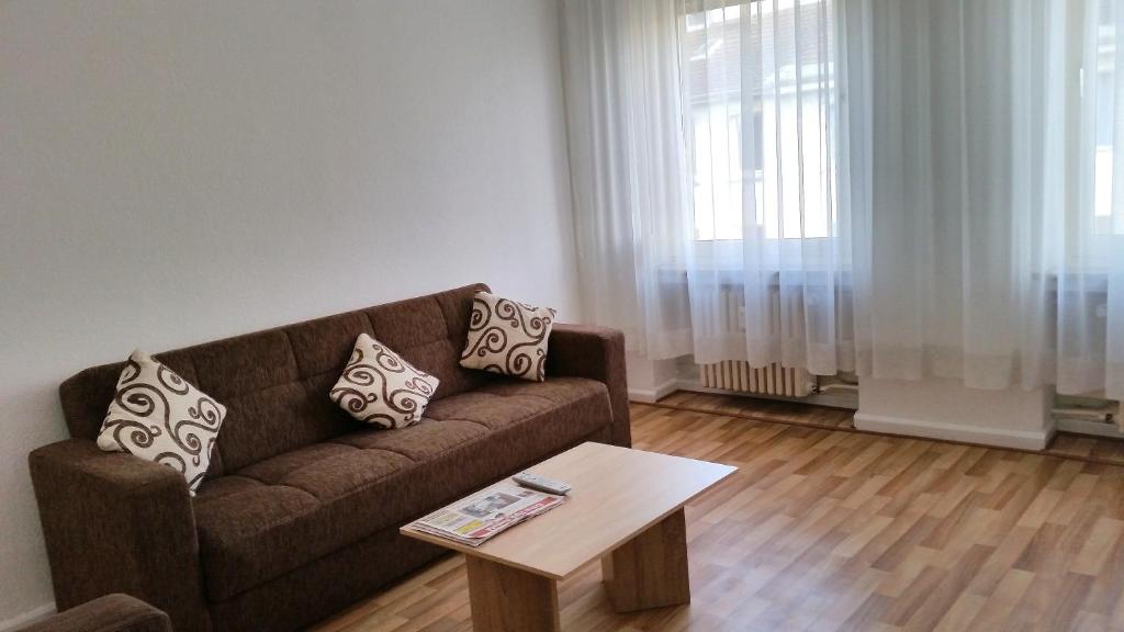 a living room with a brown couch and a coffee table at Monteurwohnungen Santos Lerch in Krefeld