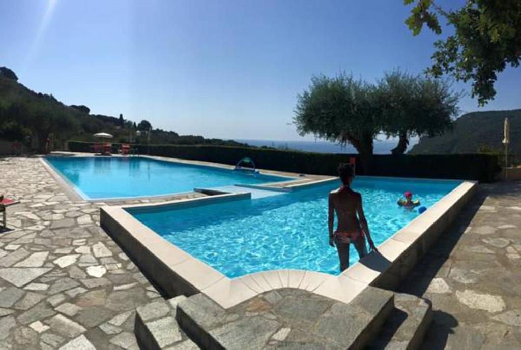 een man die voor een zwembad staat bij Casa Vacanze Mombrino in Finale Ligure
