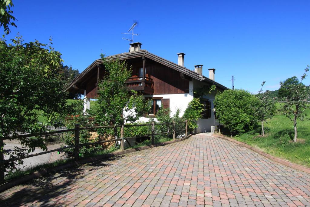 une maison avec une route en briques devant elle dans l'établissement Agritur Chelodi, à Cavalese