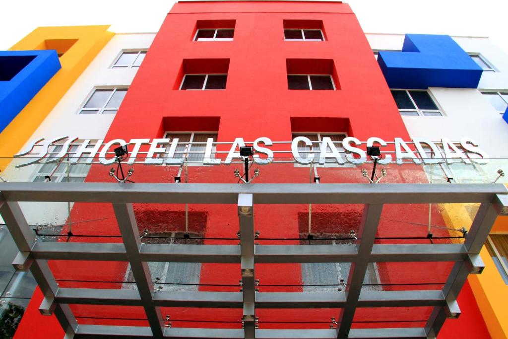 un edificio rojo con un letrero. en Hotel Las Cascadas, en San Pedro Sula
